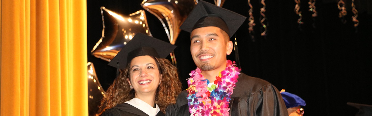 administrator and student in graduation gowns