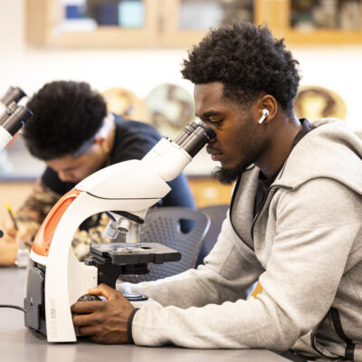 Student using microscope.